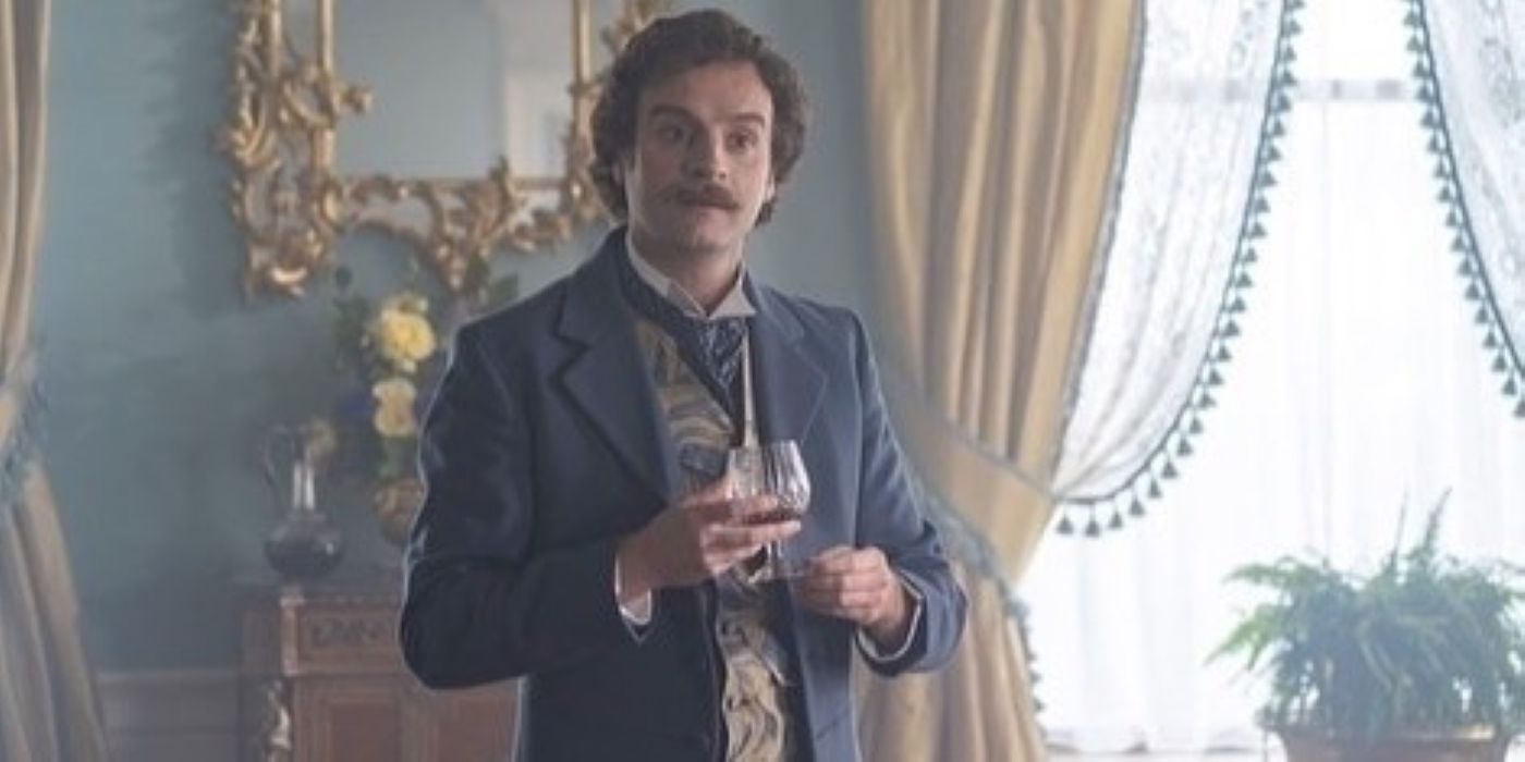 Andrew Gower como Rupert Parker segurando um copo de marca em Miss Scarlet e The Duke