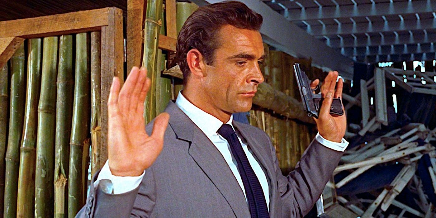 Sean Connery's James Bond stands with his hands up in Dr. No