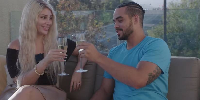 90 Day FIance's Sophie Sierra and Rob Warne drinking champagne on a couch