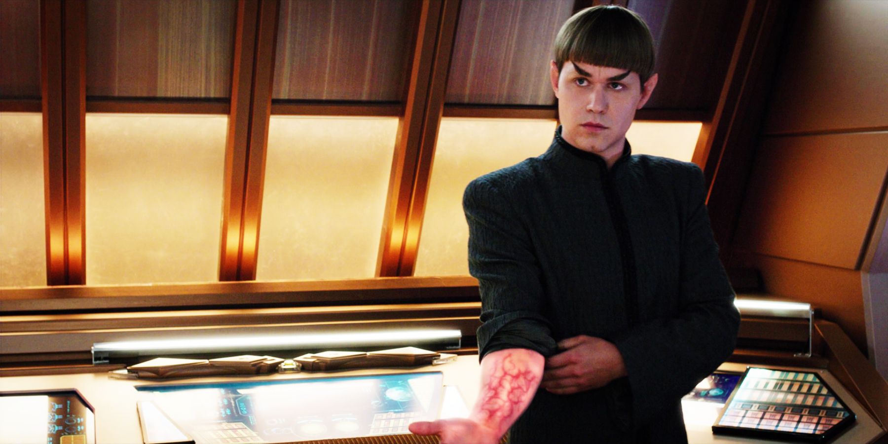 A Vulcan lifts his sleeve to reveal red liquid pulsing through his veins