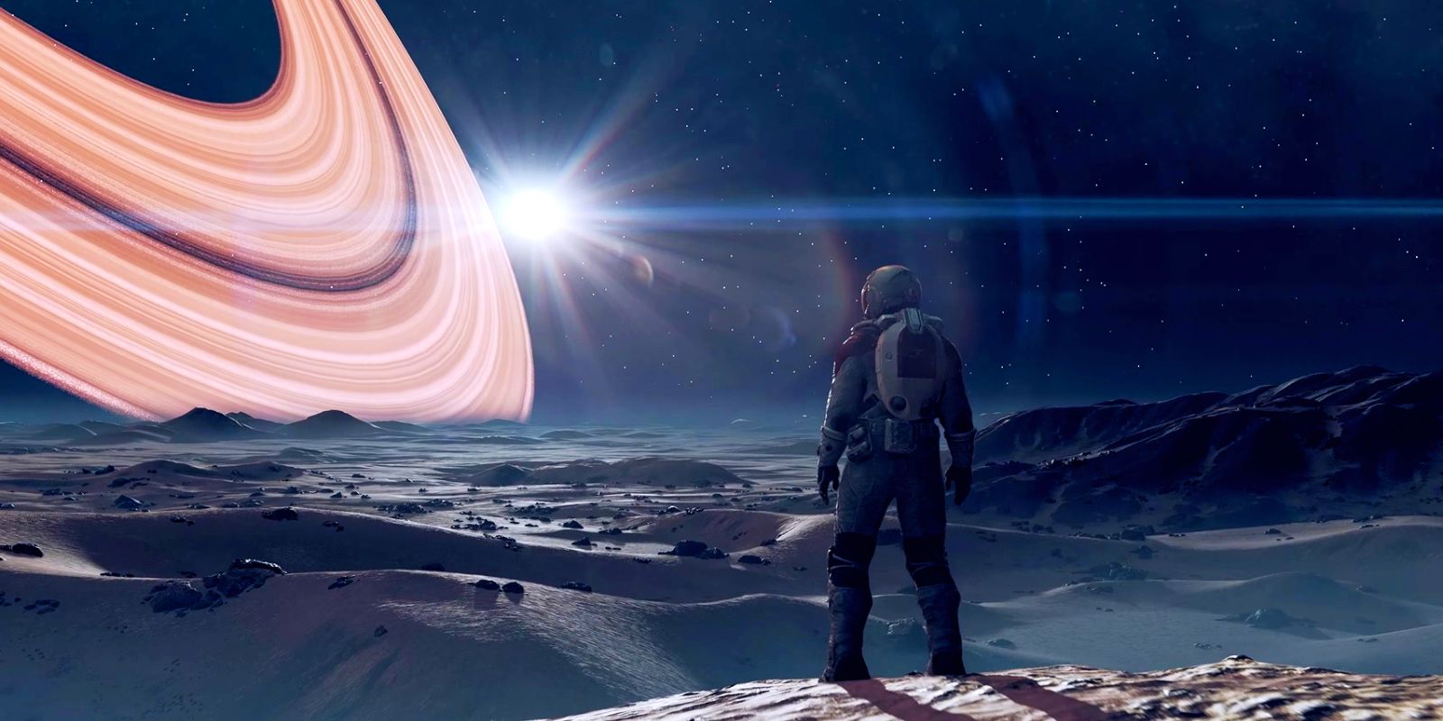 Um personagem de Starfield em um traje espacial está em uma colina, com vista para a paisagem rochosa de uma lua.  Os anéis laranja brilhantes de um planeta dominam o céu, próximo a uma estrela brilhante.