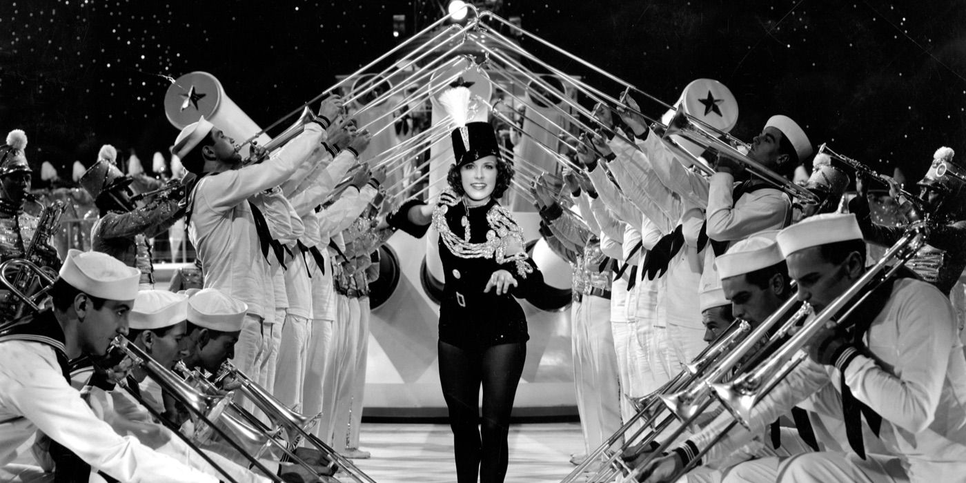 A dancer stands under a line of trumpets in Born to Dance