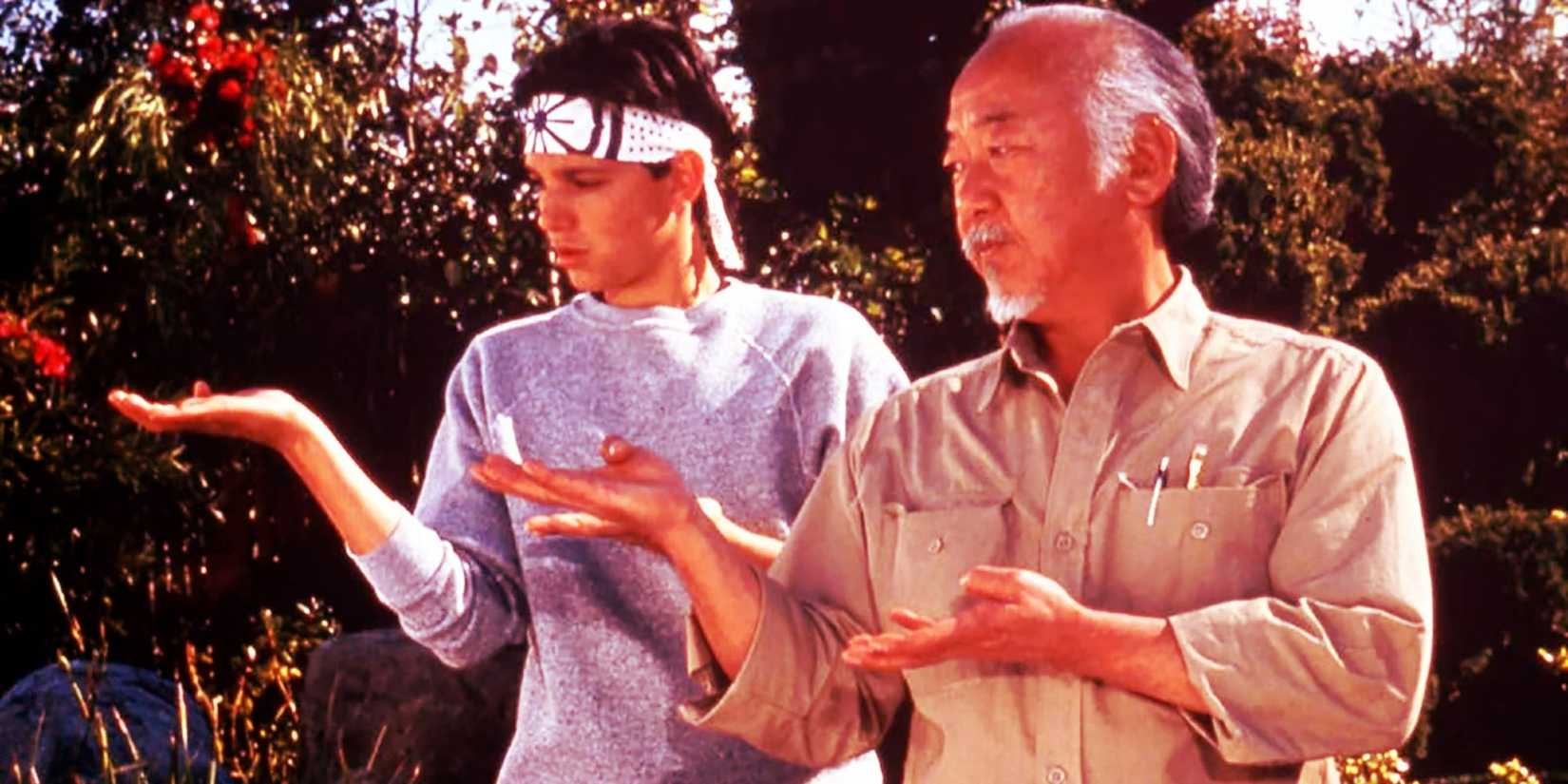 Pat Morita as Mr. Miyagi teaching Ralph Macchio as Daniel in The Karate Kid.