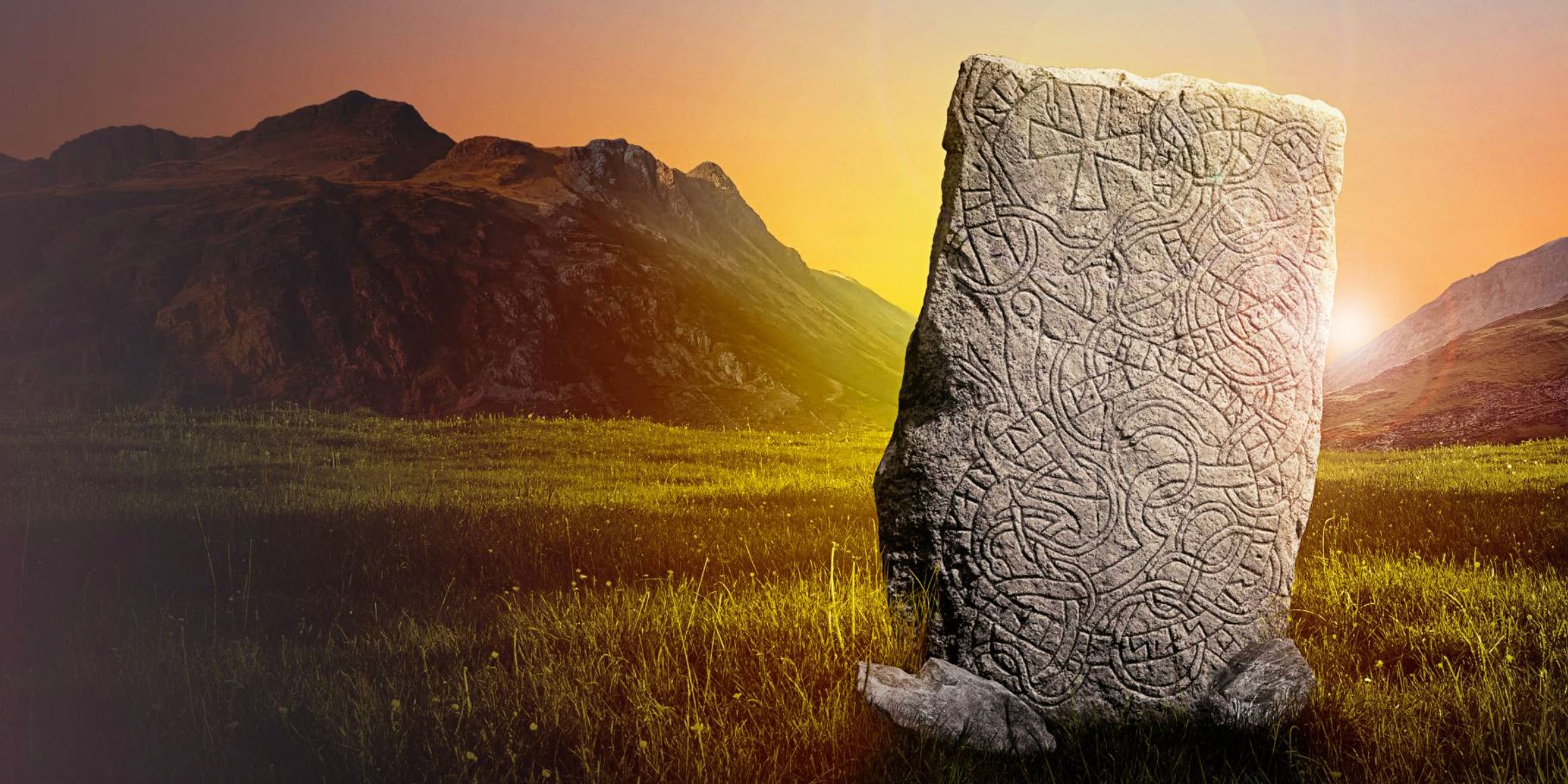 The Kensington Runestone in a field with the sun behind it