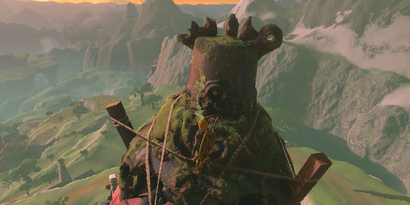 Link standing on the old- moss-covered Guardian found atop the Hateno Ancient Tech Lab in The Legend of Zelda: Tears of the Kingdom.