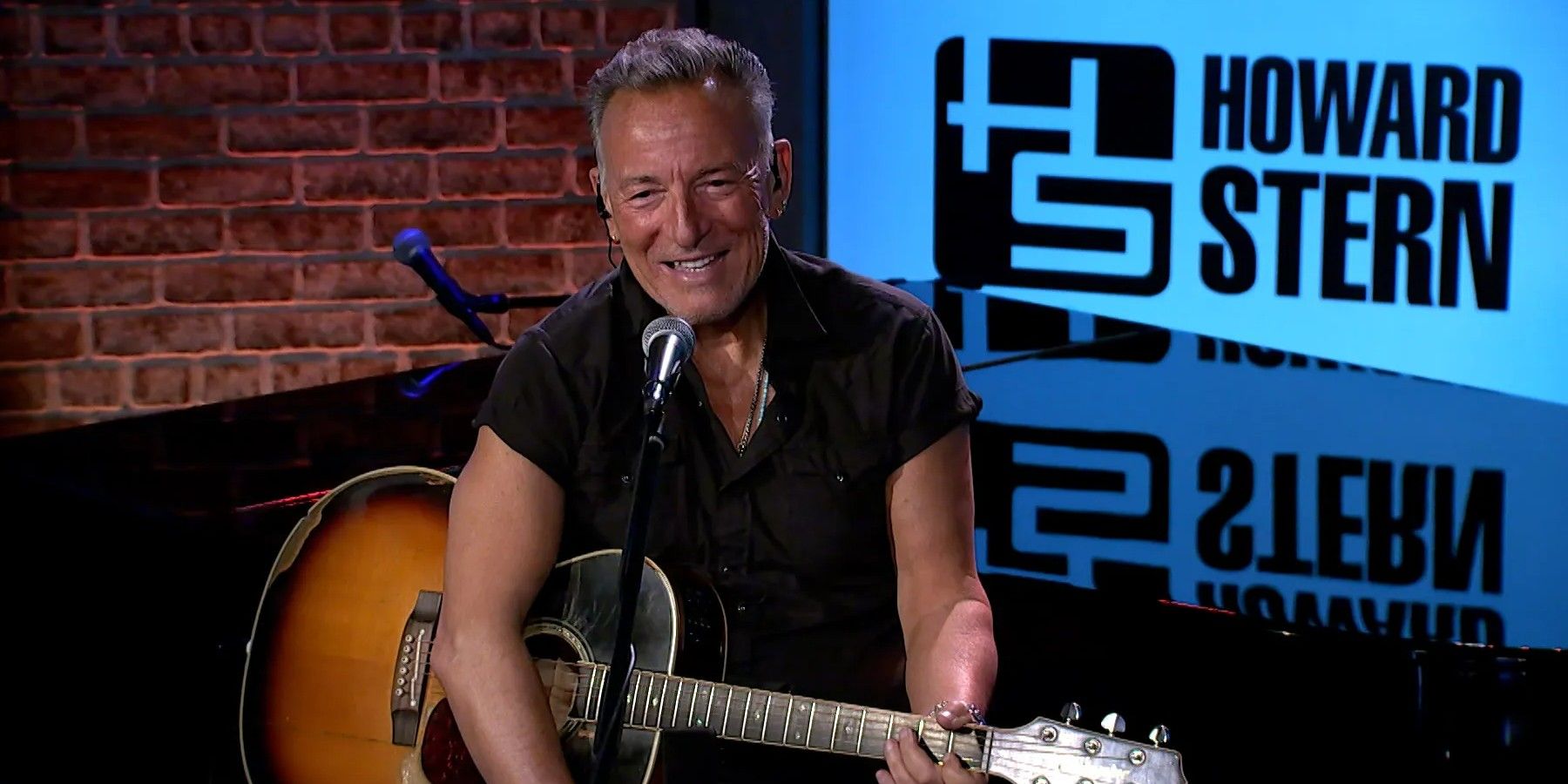 Bruce Springsteen playing a guitar on the Howard Stern Show