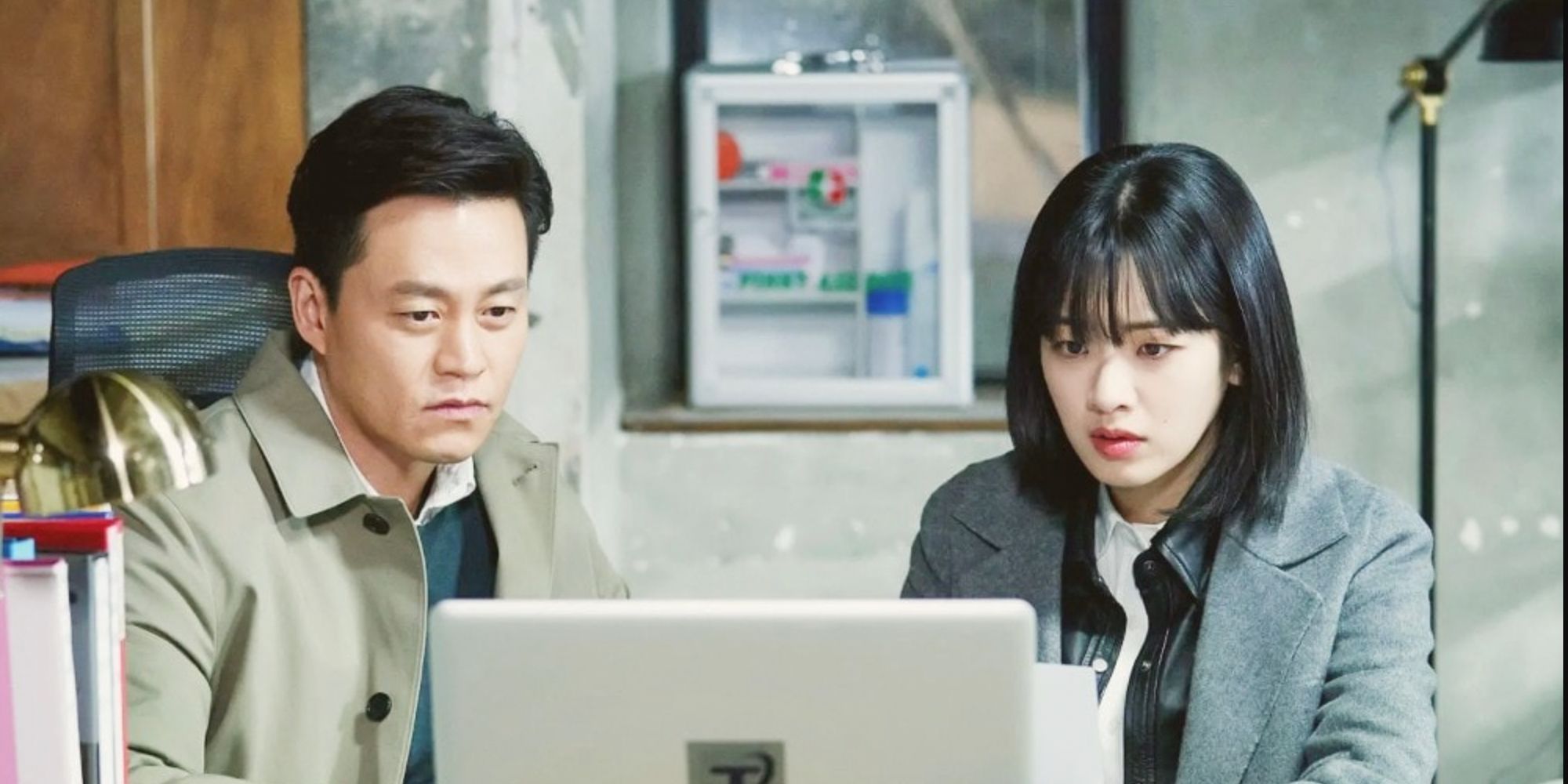 A man and woman stare at a laptop in the Korean time travel drama Times