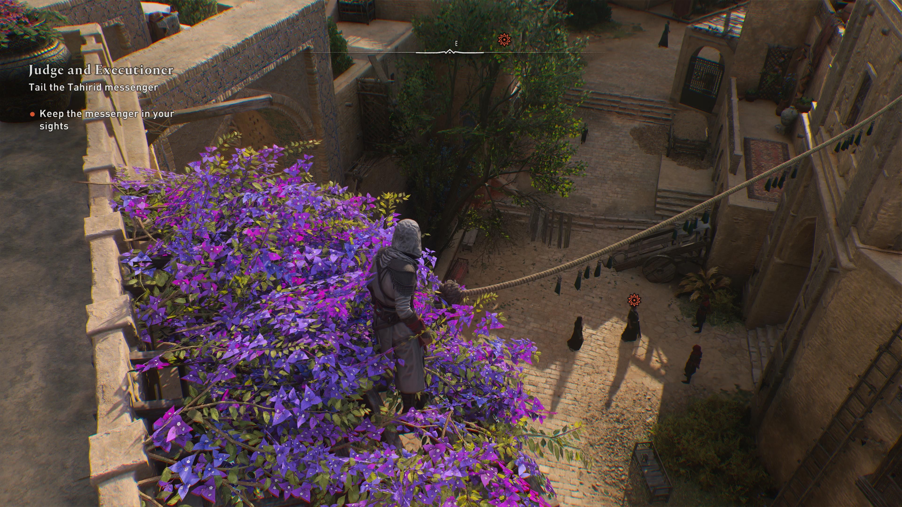 A robed figure stands on the roof of a balcony, with is covered in purple flowers. They are looking down into the street below, where there are three figures, one of which has an icon over their head. Text in the upper left corner reveals a quest name: 