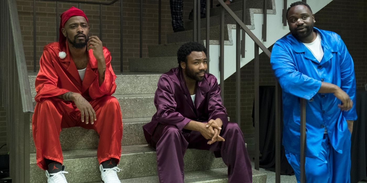 LaKeith Stanfield and Donald Glover as Darius and Earn from Atlanta sitting on a stoop, while Brian Tyree Henry as Paperboi stands beside them.
