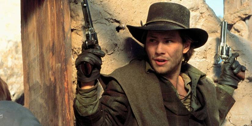 Christian Slater holding up a gun in Young Guns 2