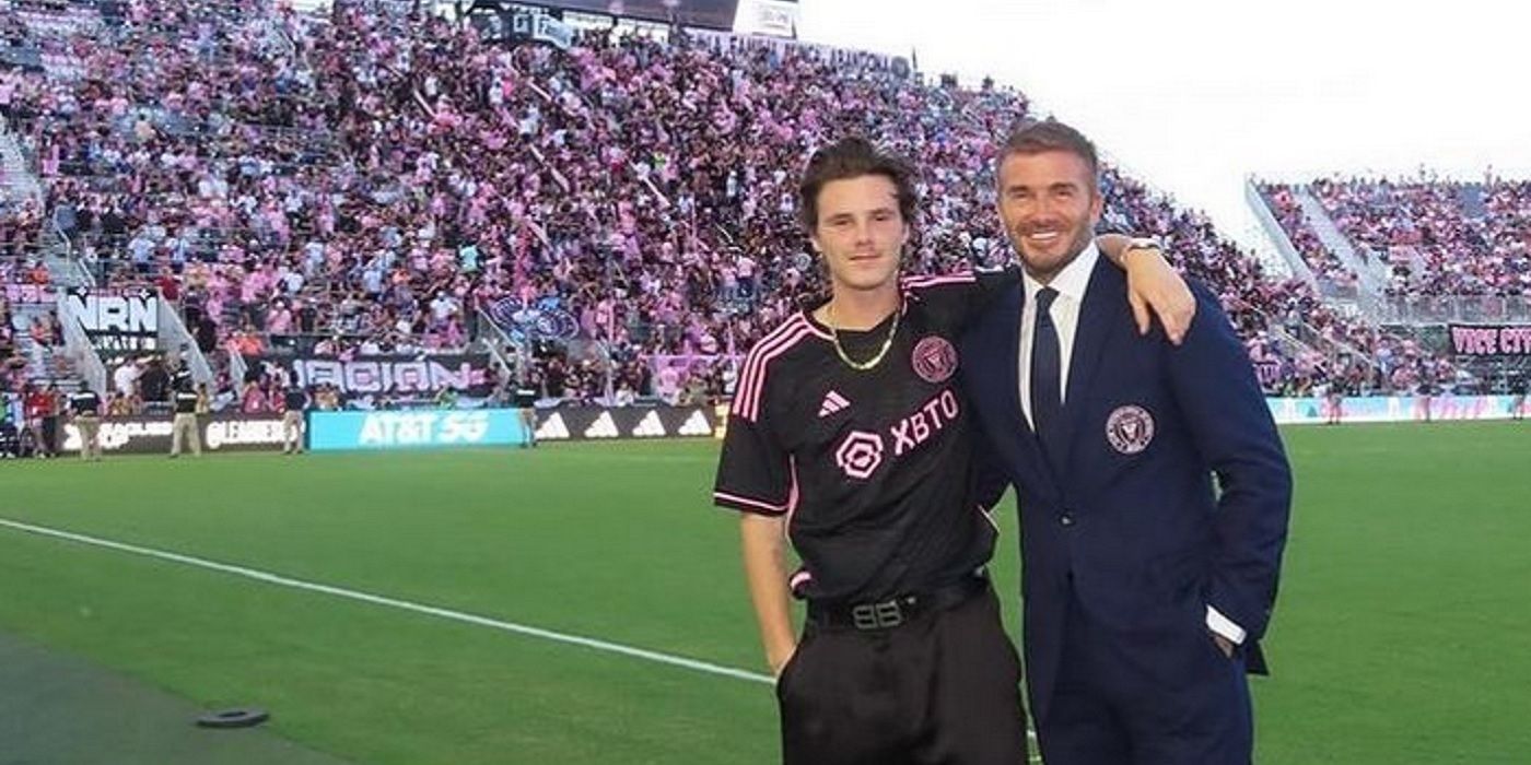 Cruz Beckham posing with David Beckham on a football field