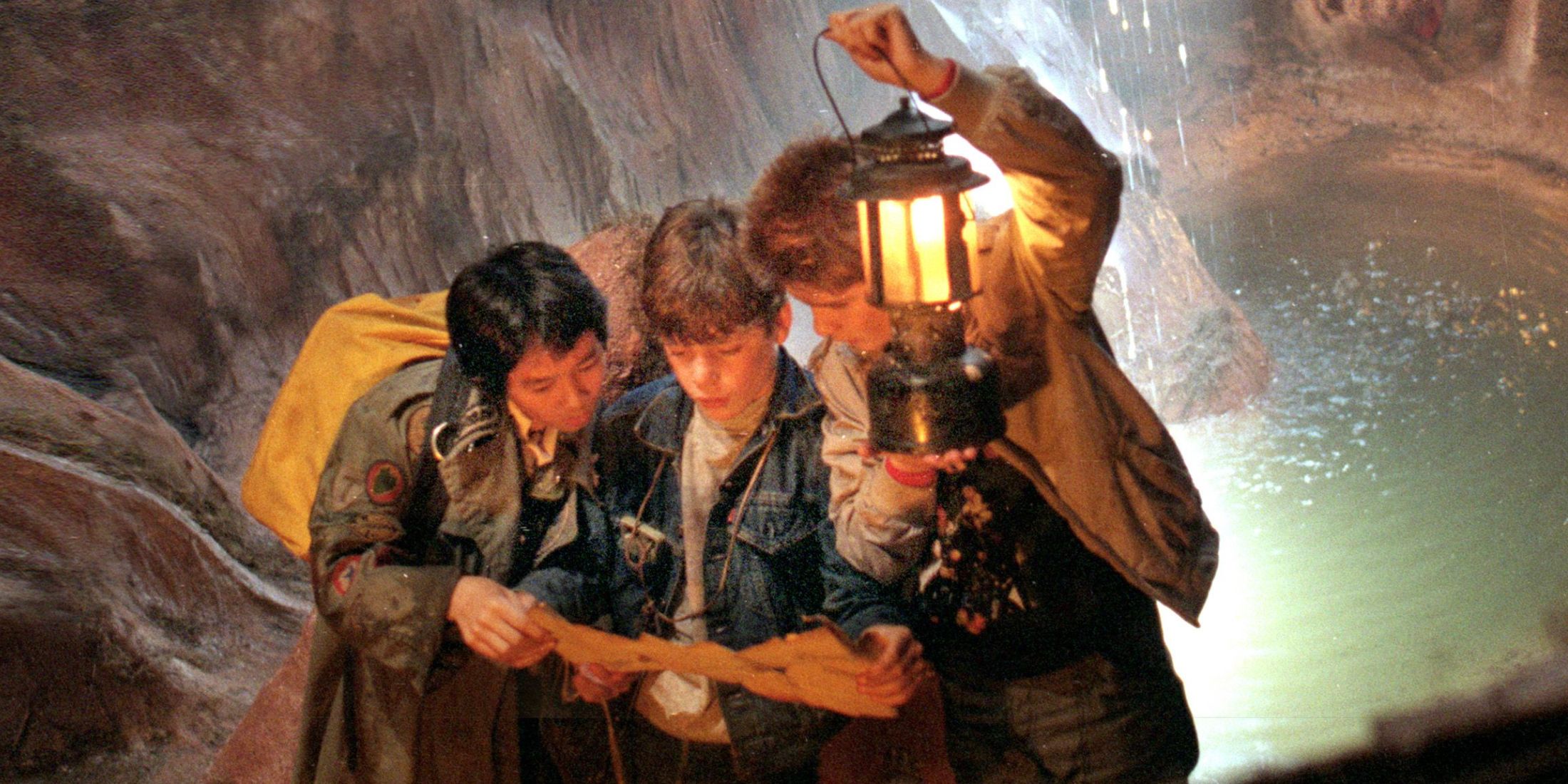 Data, Mikey, and Mouth looking at a map in a cavern in The Goonies