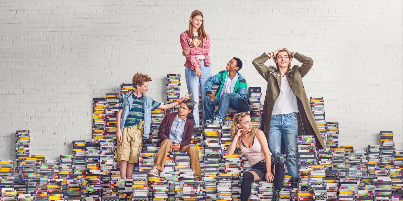 The cast of Everything Sucks! poses on VHS tapes