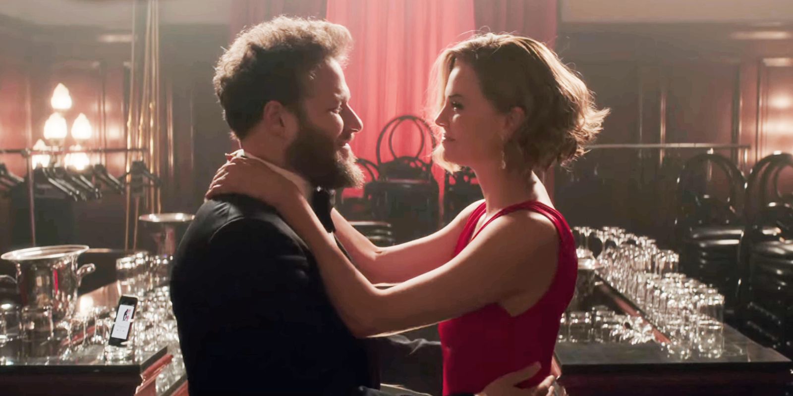 Fred (Seth Rogen) and Charlotte (Charlize Theron) embracing at an empty bar in Long Shot