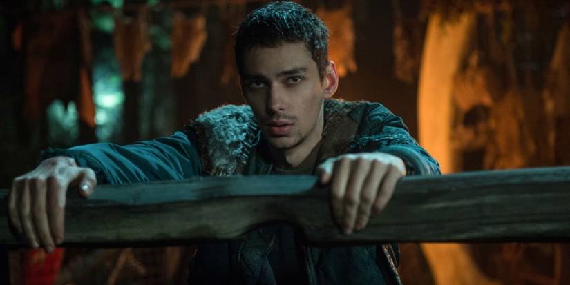 Devon Bostick as Jasper holding onto a railing in The 100