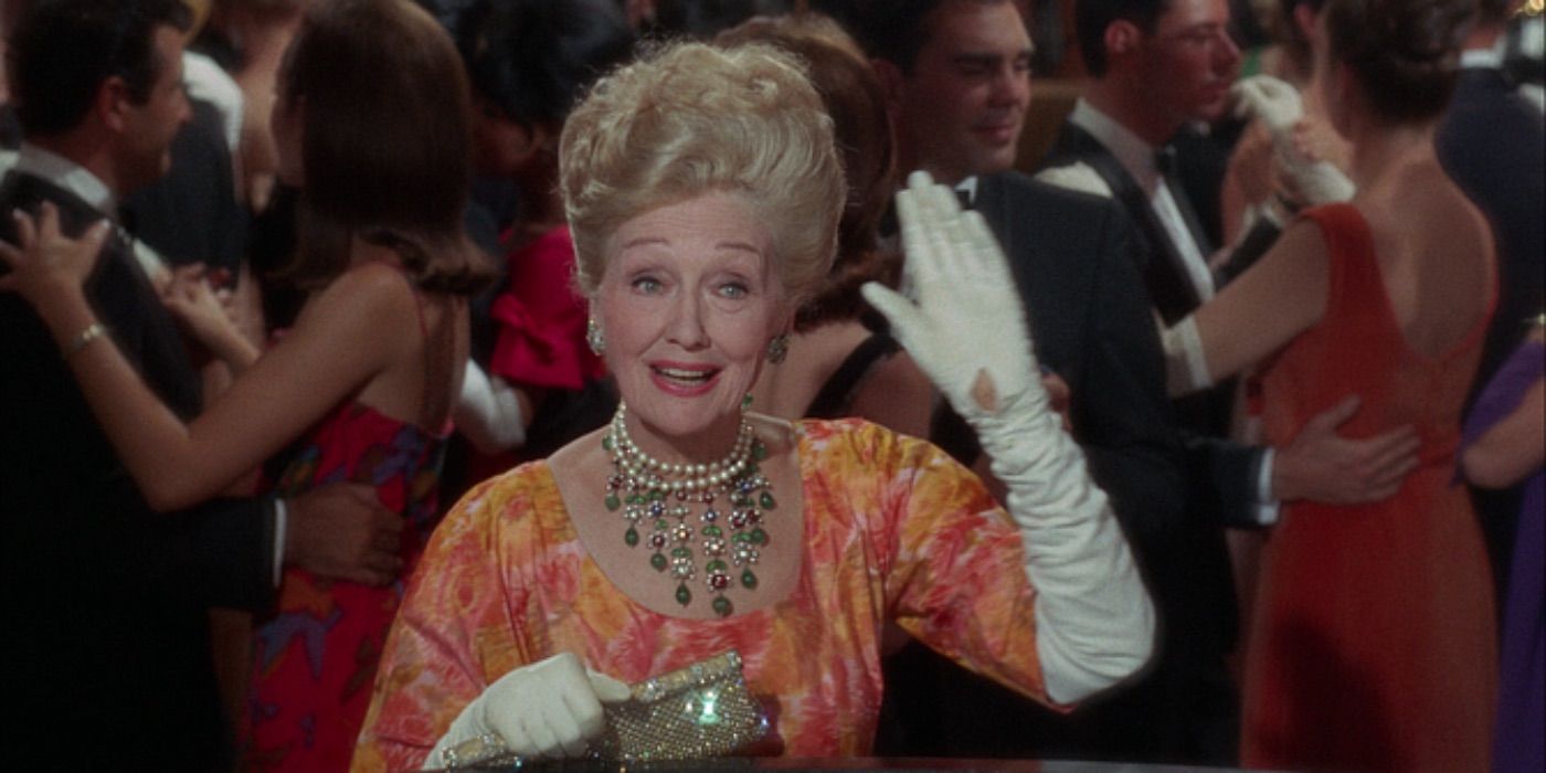 Hedda Hopper waves at a party 