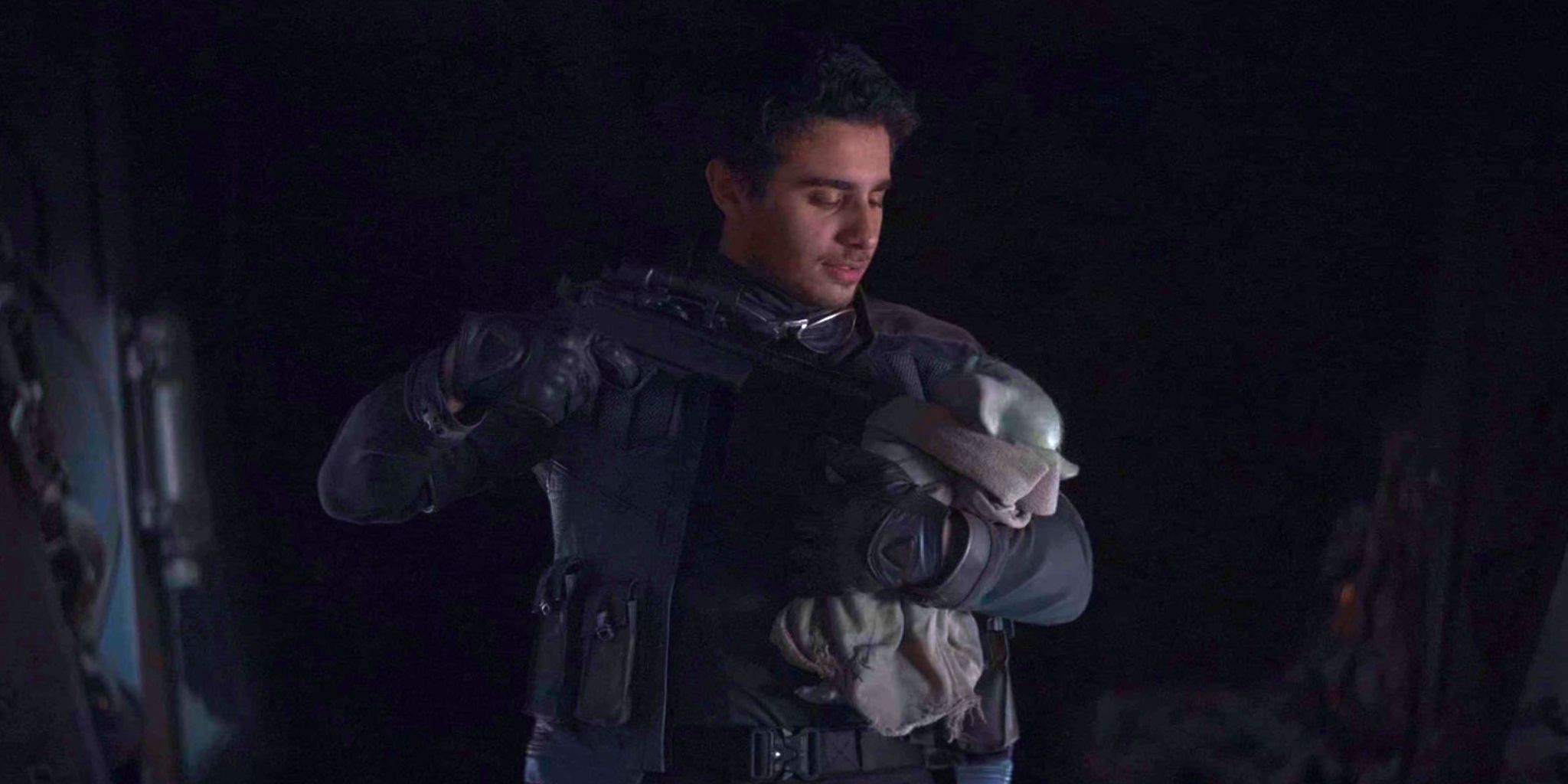 Toro Calican from The Mandalorian episode 5 holds Grogu at blaster point