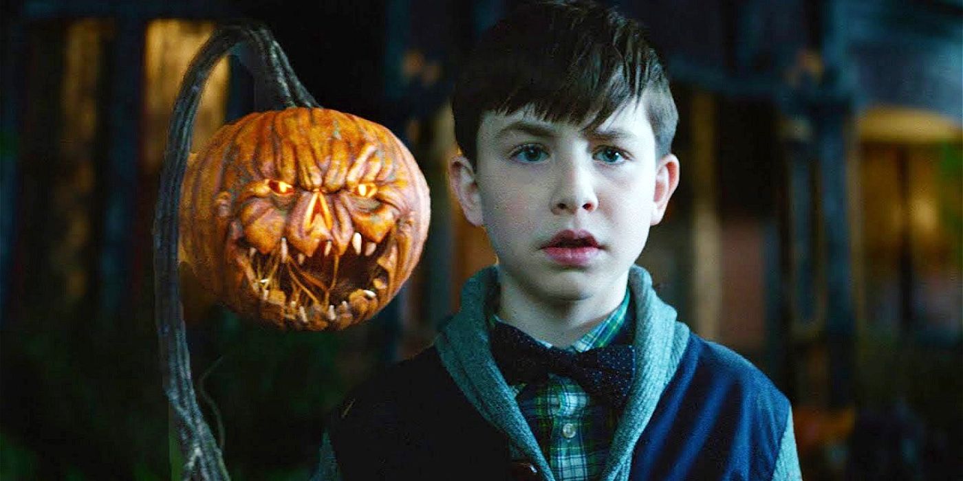 Lewis Barnavelt with a scary pumpkin head behind him in The House with a Clock in Its Walls.