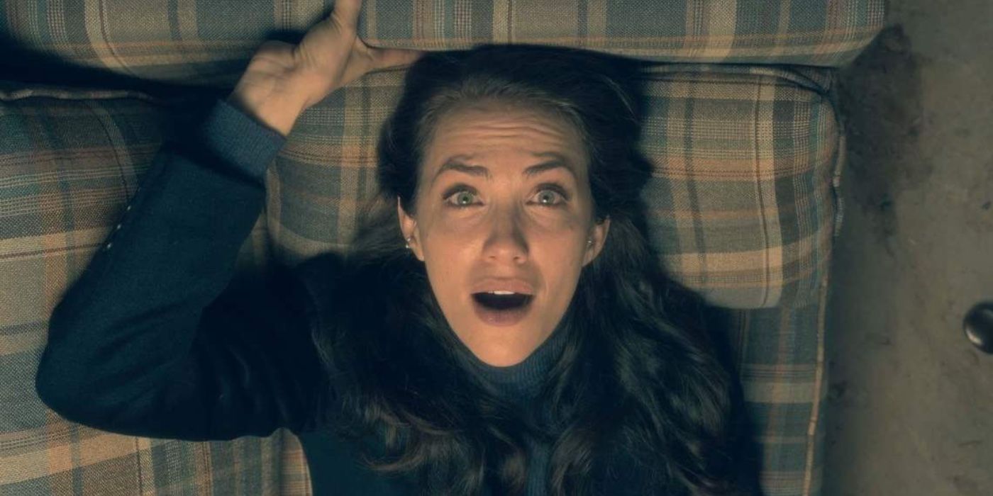 Theodora Crain looking up and holding onto the couch in The Haunting of Hill House. 