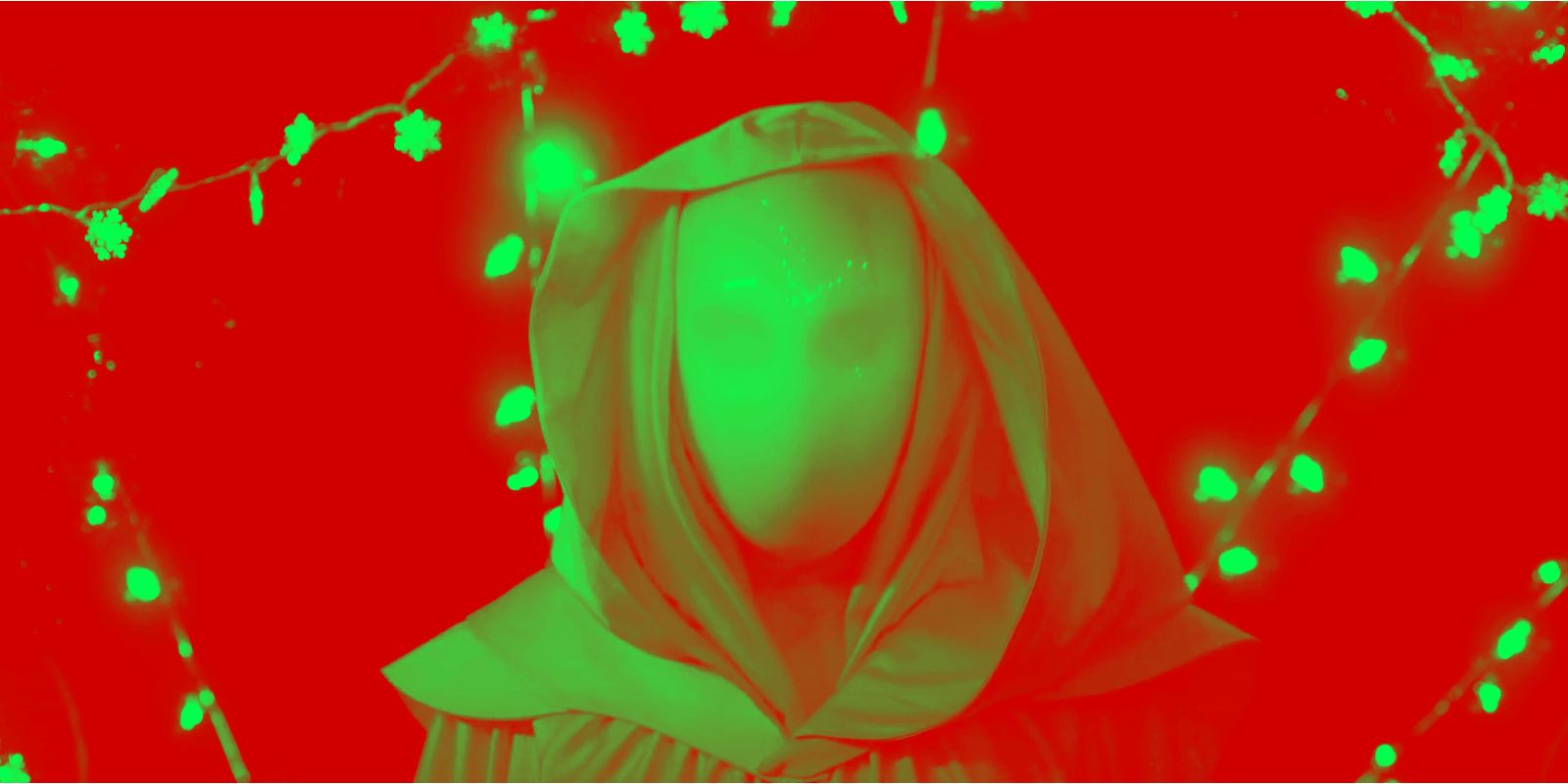 This image shows The Angel from It&rsquo;s a Wonderful Knife in front of snowflake strung lights with a green and red overlay.