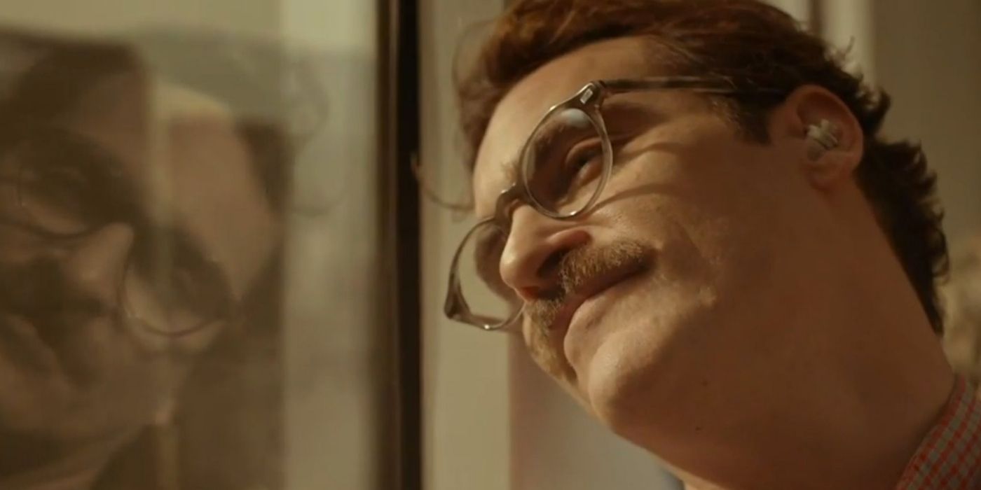 Joaquin Phoenix smiling while looking out the window in Her