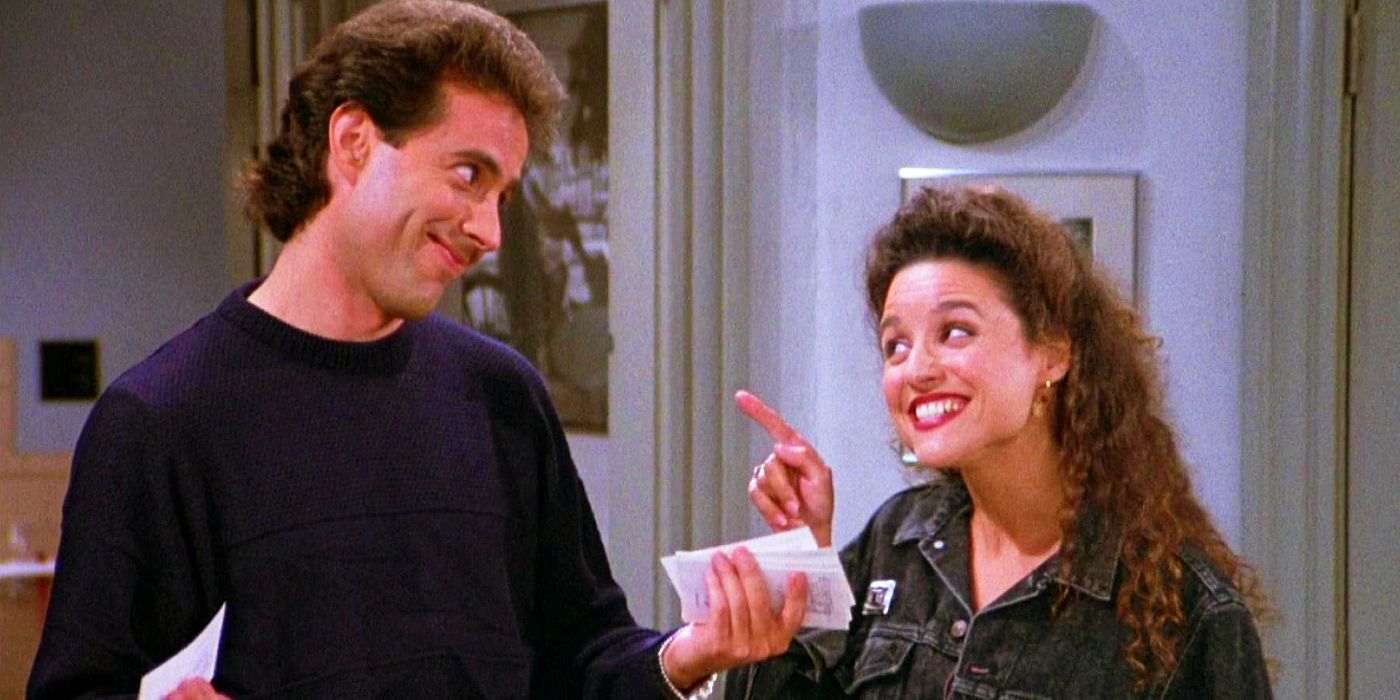 Julia Louis-Dreyfus smiling and pointing at Jerry Seinfeld in Seinfeld.
