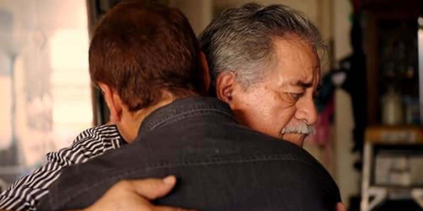 Two men embrace in Menendez + Menudo 