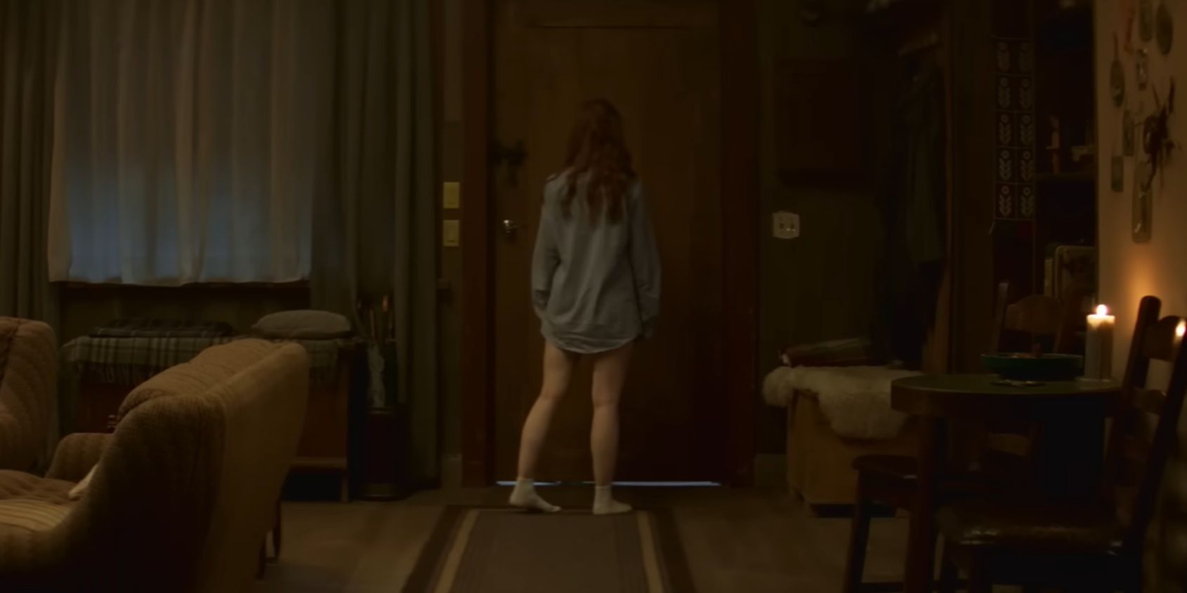 Madelaine Petsch standing by a door in The Strangers Chapter 1