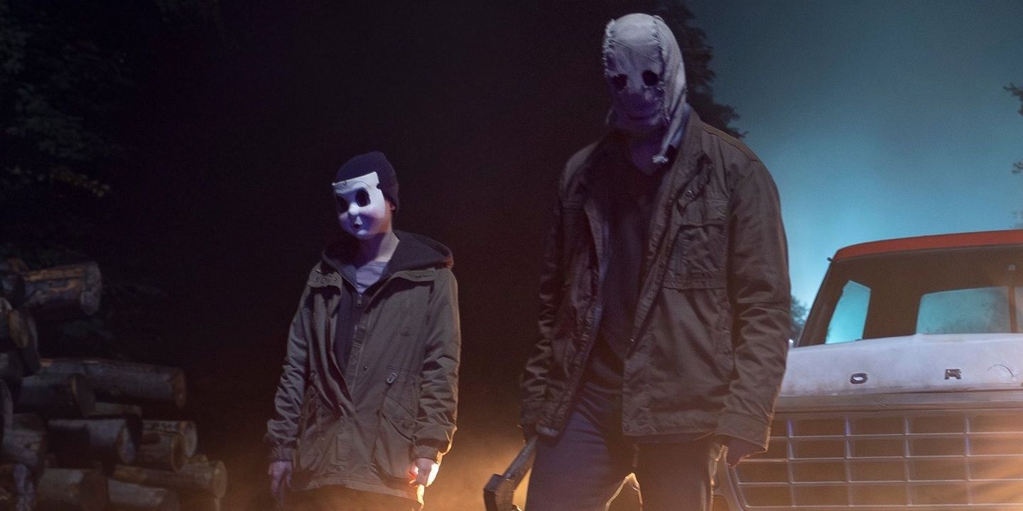 Masked killers standing by a truck in The Strangers Chapter 1