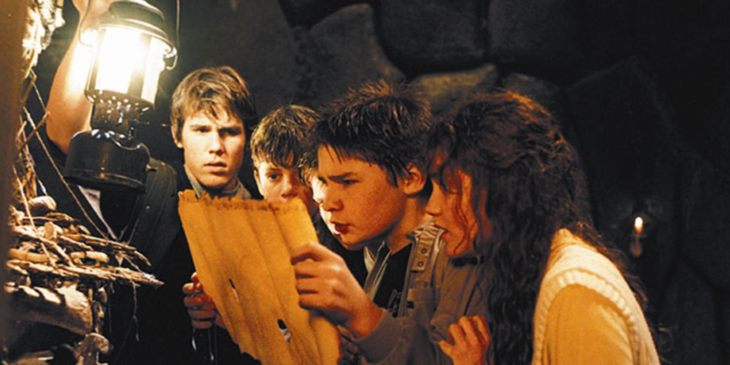 Mouth trying to read the map at the bone organ while the rest look on in The Goonies