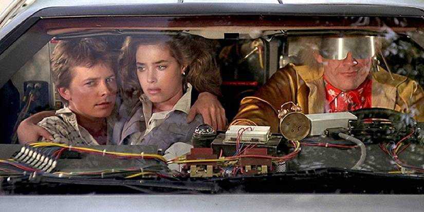 Marty and Jennifer in the front of the Delorean with Doc Brown in Back to the Future