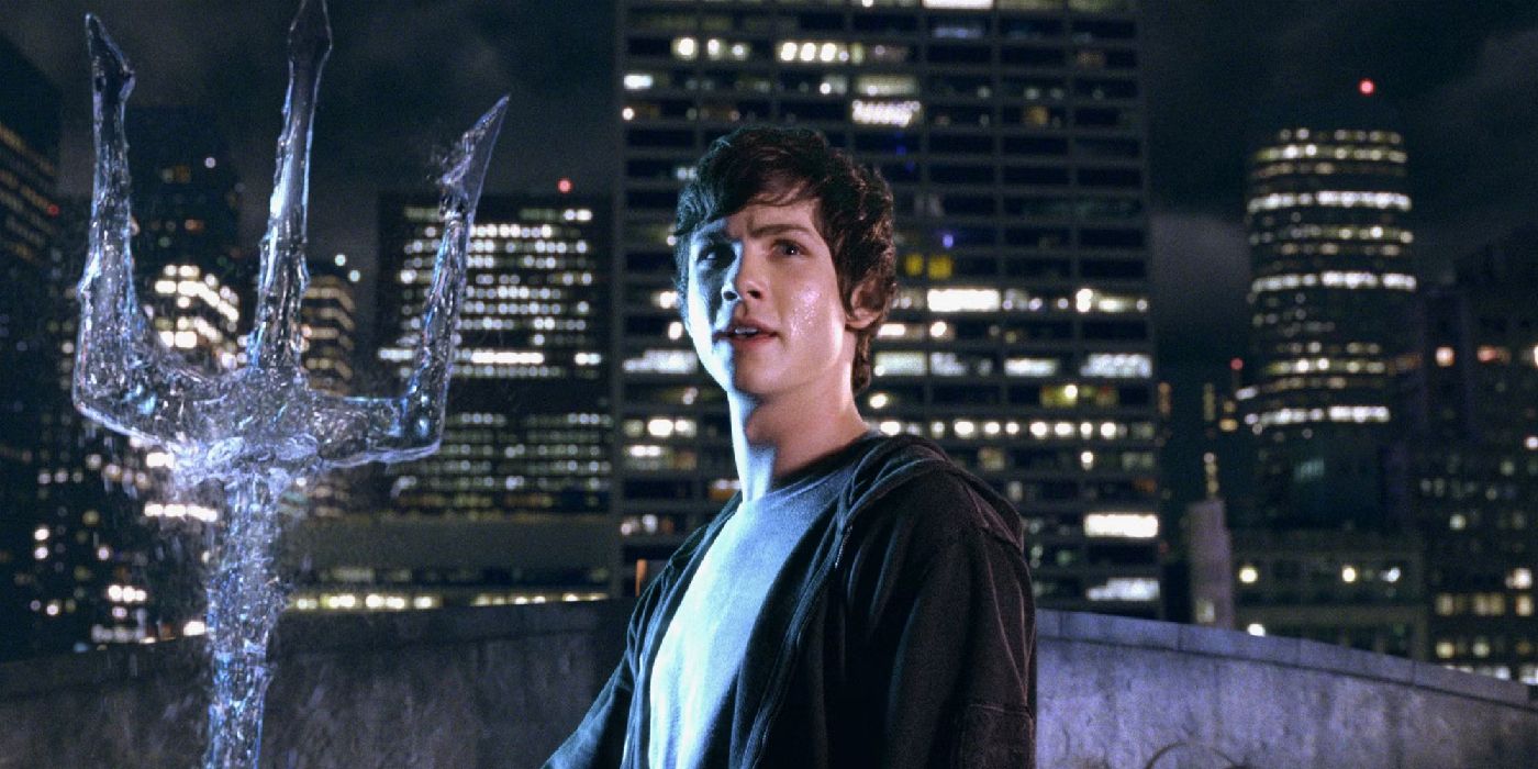 Logan Lerman como Percy segurando um tridente na frente de uma paisagem urbana em Percy Jackson e o Ladrão de Raios