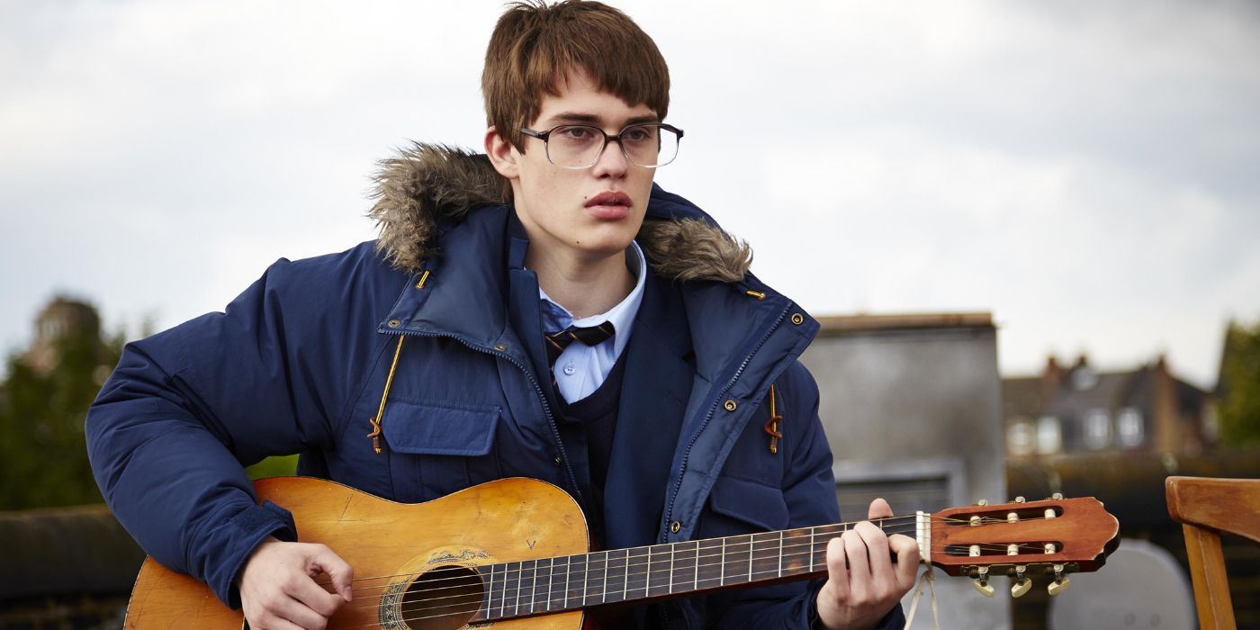 Nicholas Galitzine playing a guitar in The Beat Beneath My Feet.