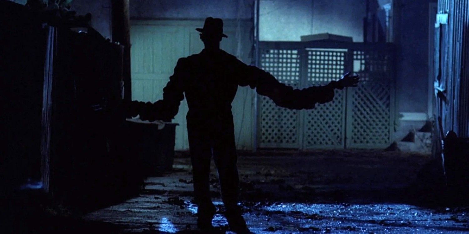 Freddy (Robert Englund) extneds his arms and walks down an alley in A Nightmare on Elm Street.