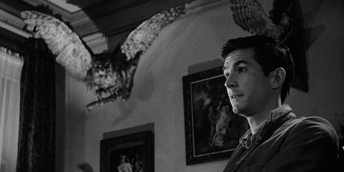 Anthony Perkins como Norman Bates com sua taxidermia atrás dele em Psicopata.