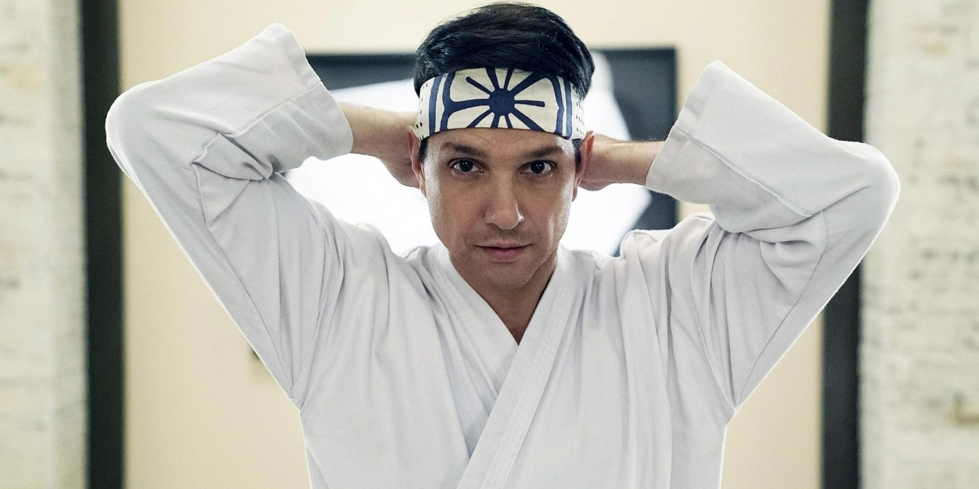 Ralph Macchio como Daniel LaRusso colocando sua bandana Miyagi-Do em Cobra Kai