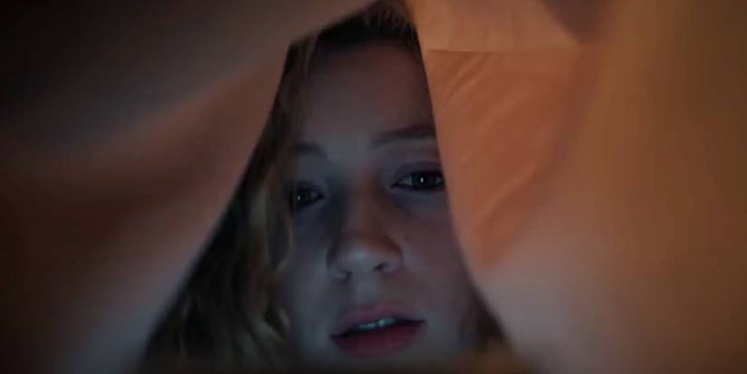 Shelby hiding under the covers in American Horror Stories Bestie