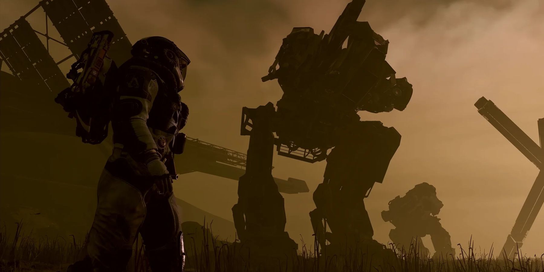 A person in a spacesuit standing next to a very tall mech, which appears to be decommissioned in a junk yard.
