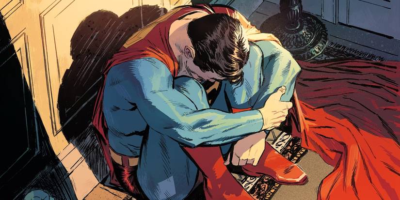 Comic book art: Superman looks sad curled in a ball.