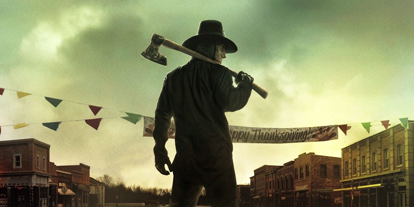 A hat-wearing figure stands in the middle of a small-town street with an axe held over his shoulder.