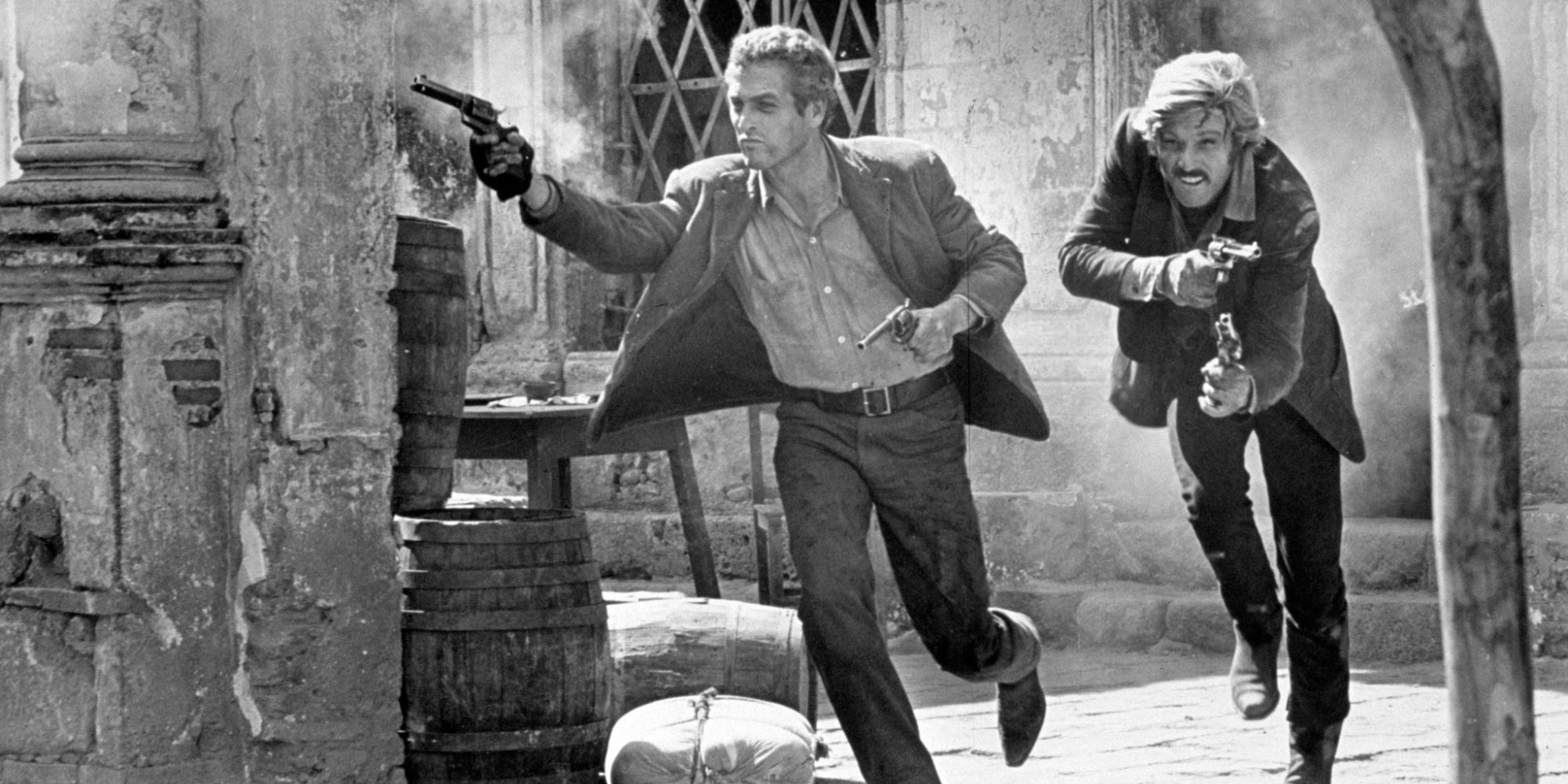 The Ending of Butch Cassidy and the Sundance Kid with Butch Cassidy (Paul Newman) and Sundance Kid (Robert Redford) running and shooting guns in black and white
