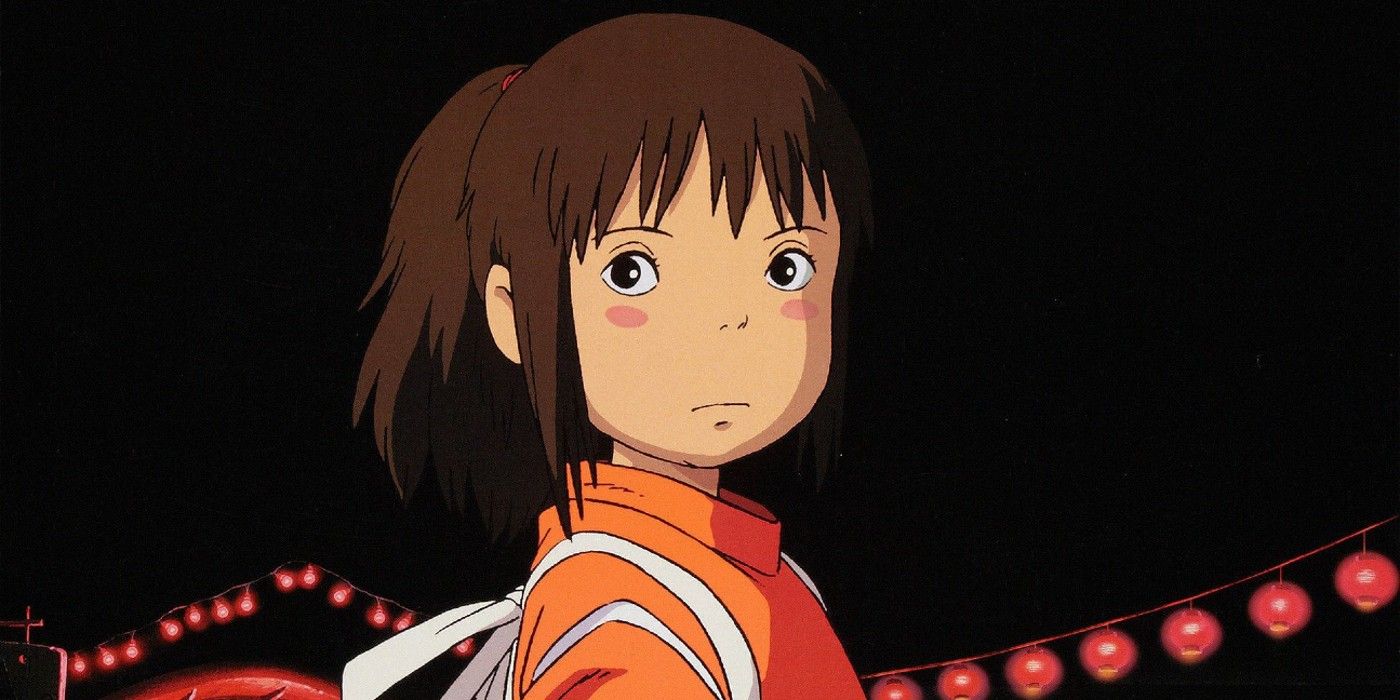 Chihiro Ogino looking back and frowning in Spirited Away with lanterns strung up behind her