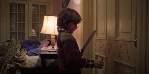 Danny writing Redrum on the door and holding a knife in The Shining