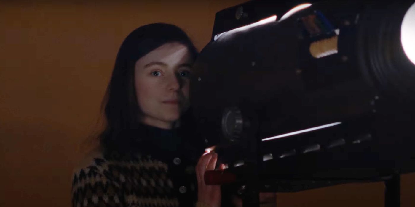 Thomasin McKenzie standing behind a large light in Eileen.