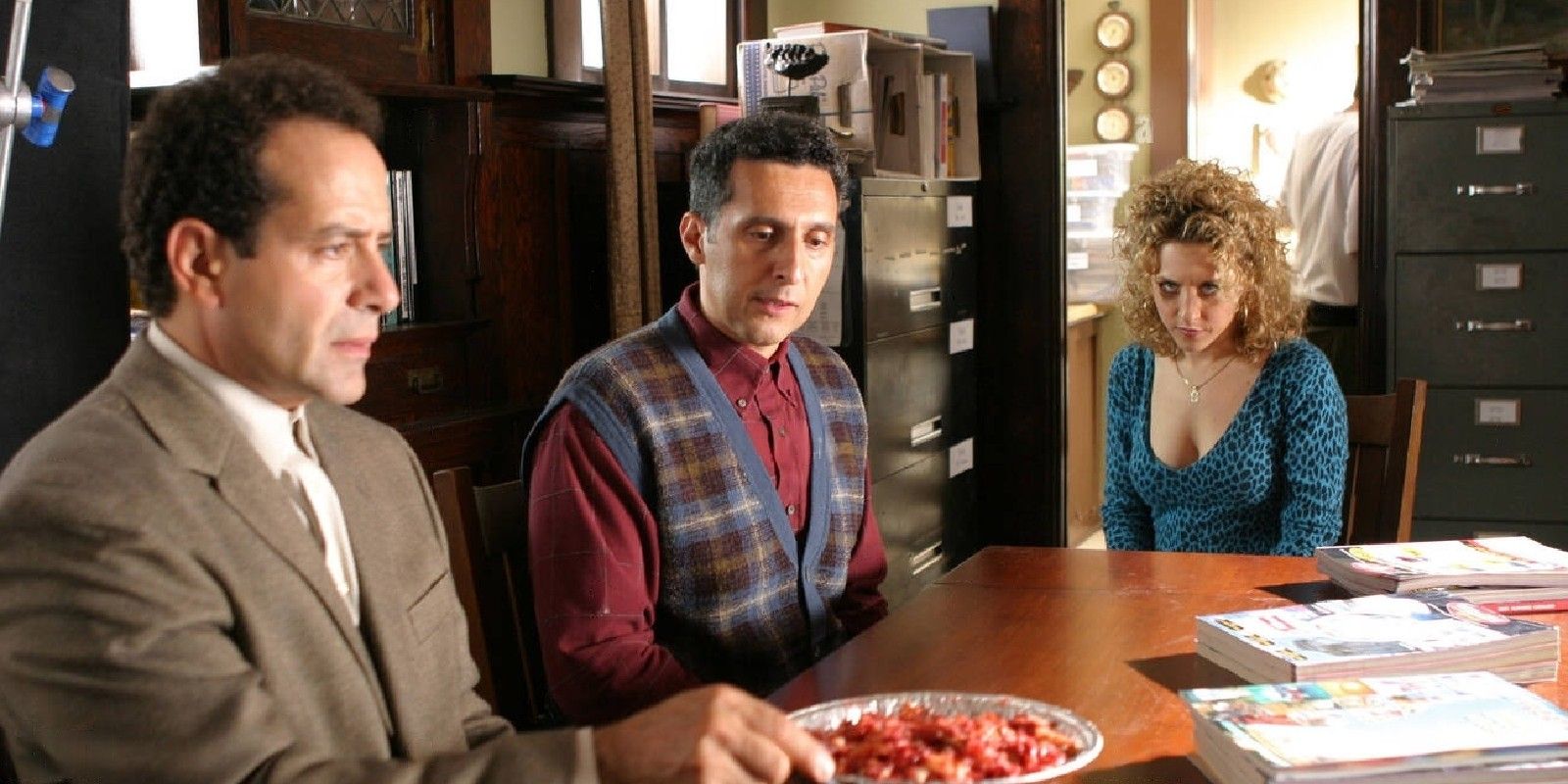 Monk and his brother with a pie in front of them while Sharona sits nearby in the series Monk