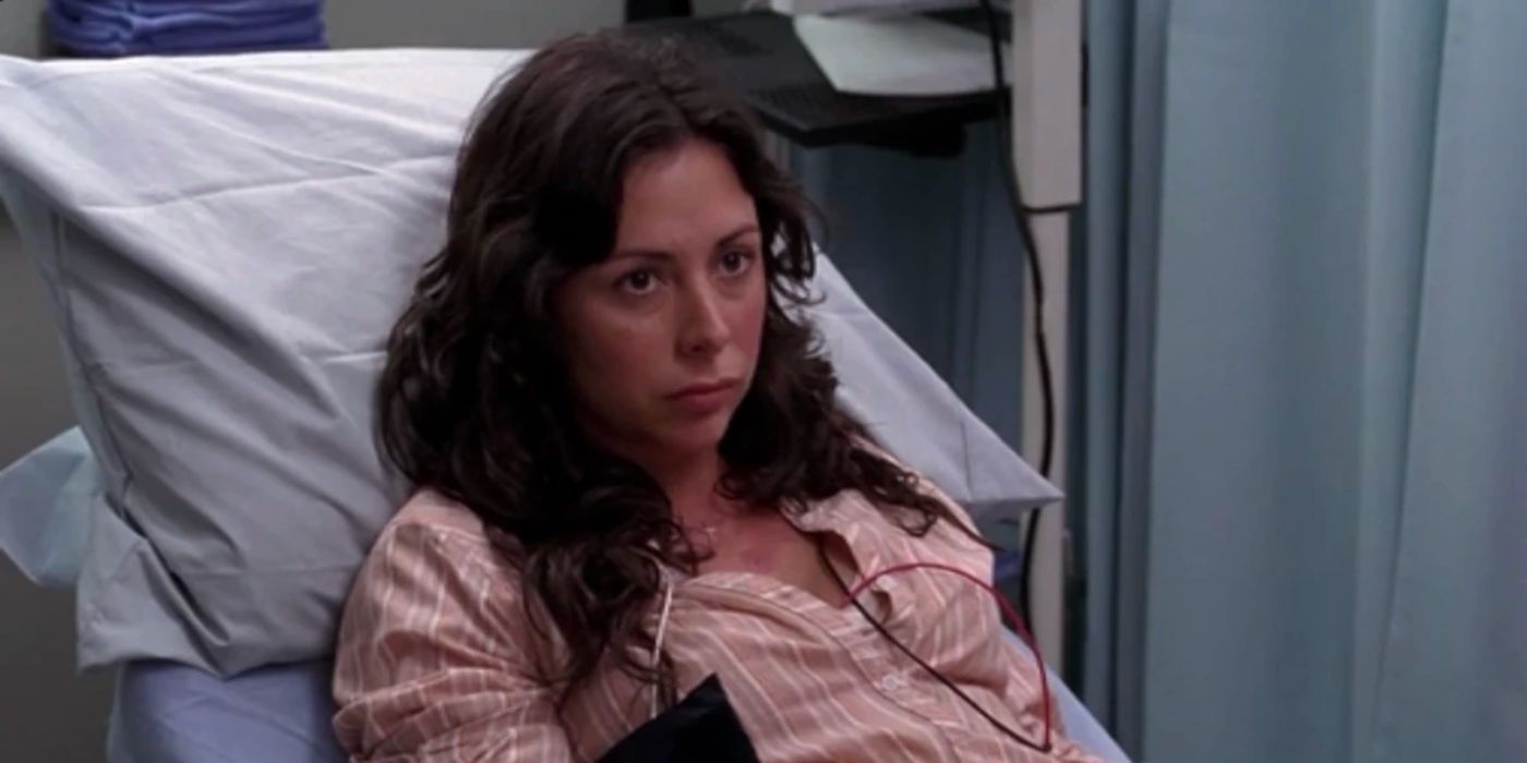 A woman is sitting in a hospital bed.