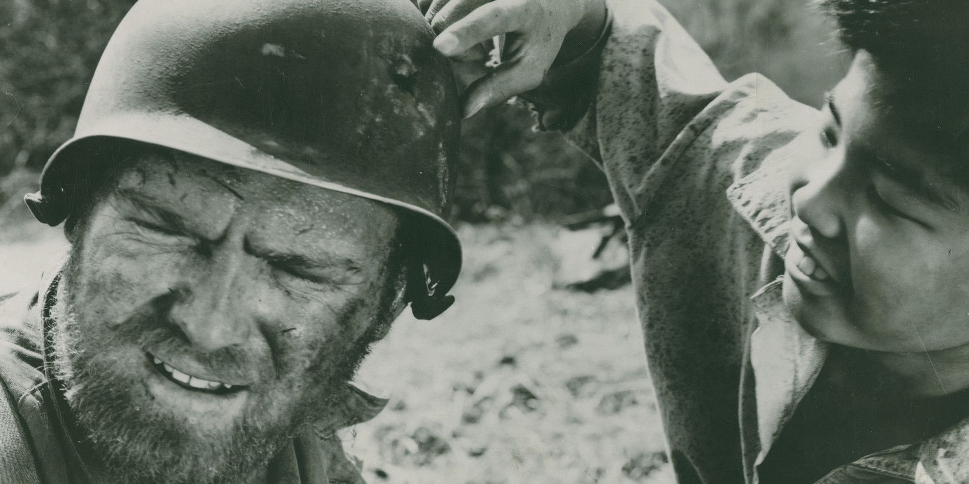 A Korean boy examining Zack's helmet in The Steel Helmet.