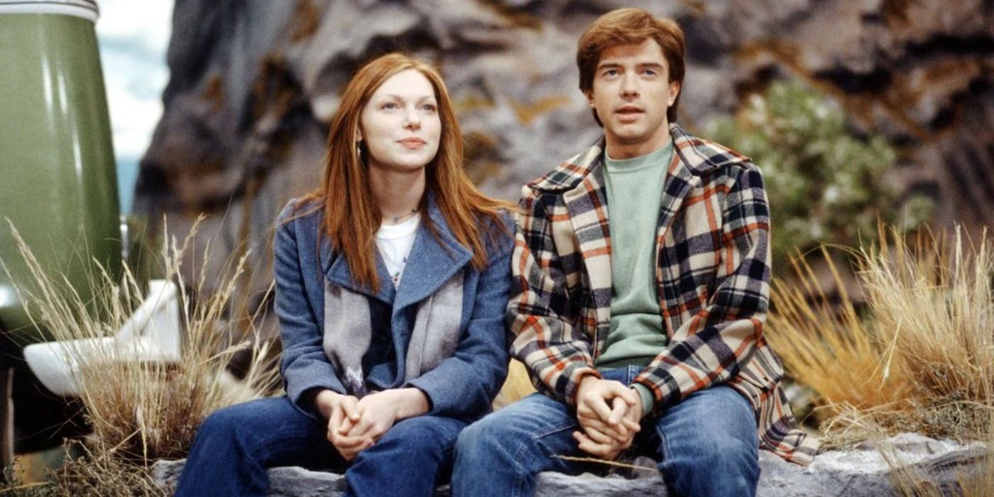 Donna (Laura Prepon) and Eric (Topher Grace) sitting on a rock in That '70s Show.
