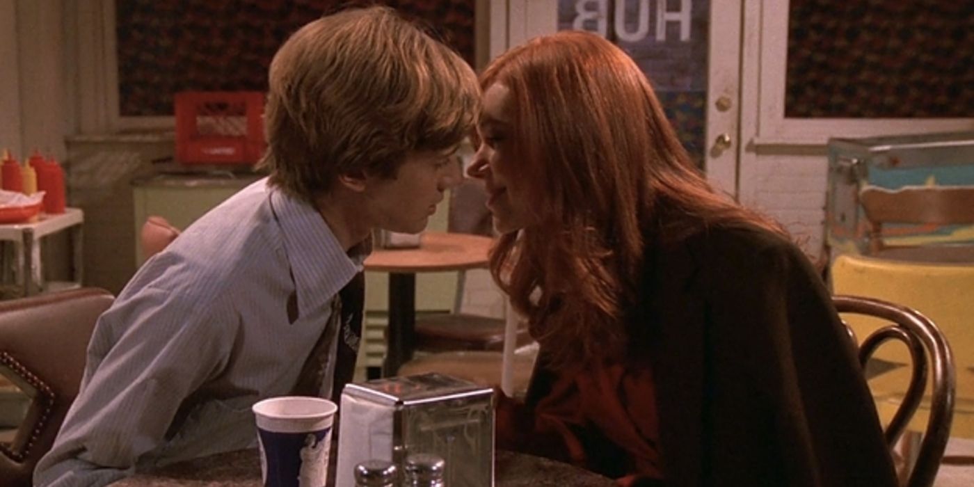 Donna (Laura Prepon) and Eric (Topher Grace) lean in for a kiss on That '70s Show.