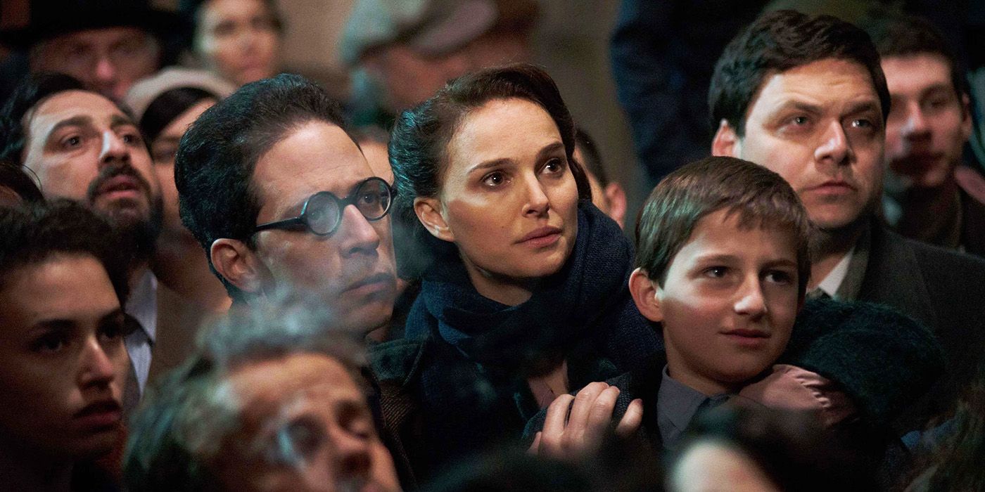 Natalie Portman com uma expressão sombria no meio da multidão no filme A Tale of Love and Darkness